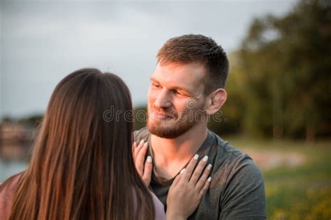 Young Man In Love Looking At His Partner And Hugging Her Outdoors Stock