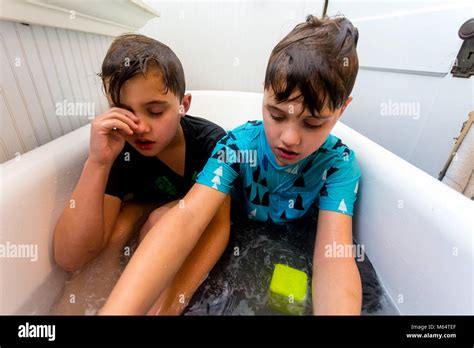 Twin Caucasian Brothers Play In Their Water Filled Bathtub Together