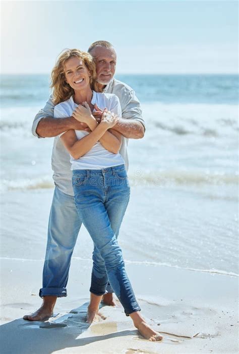 Portrait Of A Happy And Loving Mature Couple Enjoying A Day At The Beach In Summer Cheerful