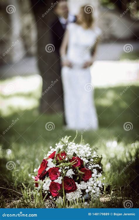 Wedding Flowers In Foreground And Bride And Groom Blurred In Background