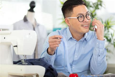 Handsome Fashion Designer Sewing With Sewing Machine Stock Photo