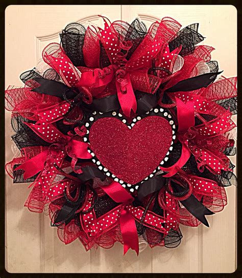 A Red And Black Mesh Heart Wreath Hanging On A Door