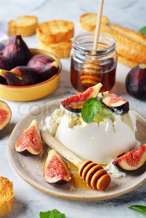2 slices (40g) of hard cheese; Ricotta cheese with honey and figs on a ... | Stock image ...