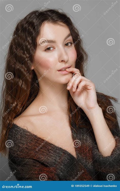 Young Fashion Model In Knitted Woolen Coat Biting Her Finger Stock