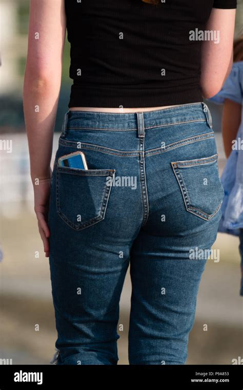 A Young Woman Wearing Jeans With Her Mobile Cell Phone