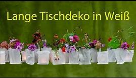 Festliche, lange weiße Tischdekoration mit weißen Tüten, Blumen und Teelichtern selber machen