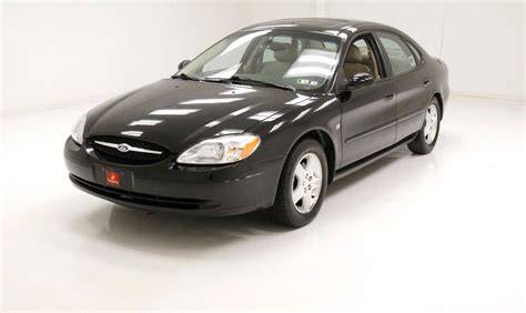 A clean 02 Ford Taurus sedan parked on a street, showcasing its classic design.