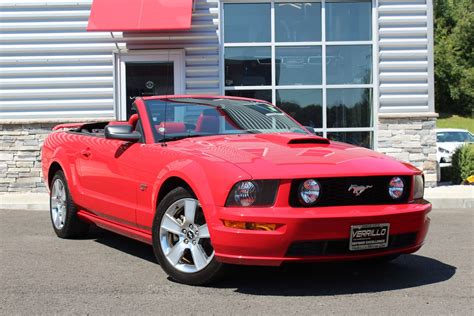 Mechanic working on the engine of a 07 Ford Mustang Convertible