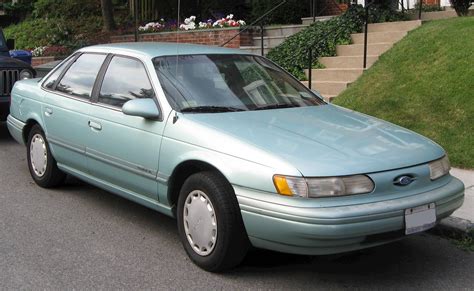 A front three-quarter view of a clean, dark-colored 1992 Ford Taurus sedan parked on a street.