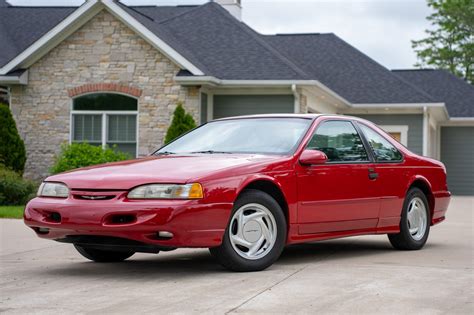 A sleek 1994 Ford Thunderbird parked on a scenic road