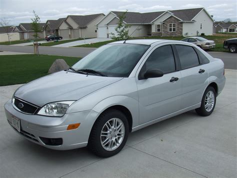 A clean silver 2006 Ford Focus sedan parked on a suburban street