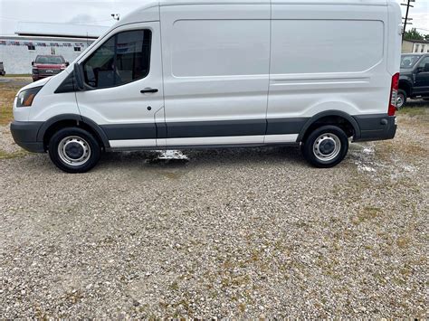 Overview of a 2016 Ford Transit van parked in a commercial setting