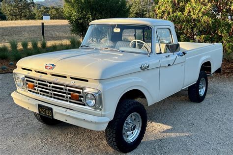 A pristine 1964 Ford F100 truck in a classic blue color, showcasing its iconic design