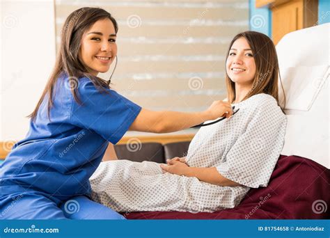 A smiling nurse checking on a patient in their room