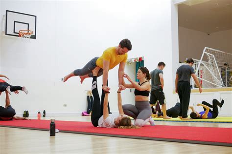 People practicing Acroyoga in a class setting