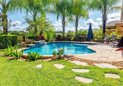 Tropical landscaping featuring palm trees, Arizona Cypress privacy
