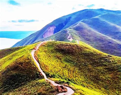 Wisatawan berfoto di puncak Bukit Holbung dengan latar Danau Toba