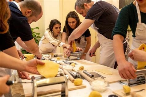 A group of people in a kitchen in Florence, learning to make pasta from a local chef