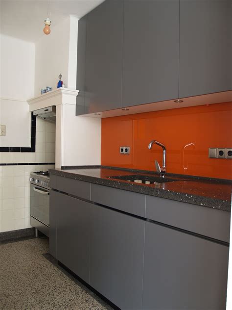 modern kitchen in orange and gray back wall in brick look brick 
