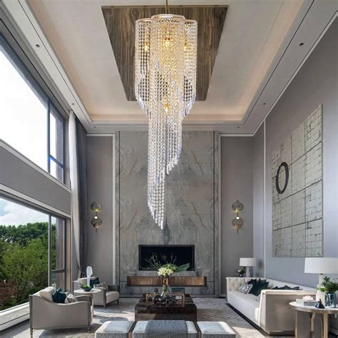 A classic chandelier hanging from a high ceiling in a luxurious front room.