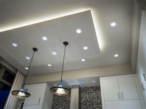 A grid of recessed lights embedded in a modern ceiling, casting a warm glow on a cozy front room.
