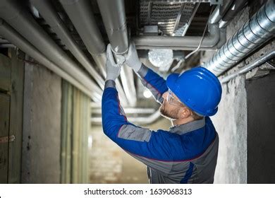 Handyman inspecting a leaking pipe