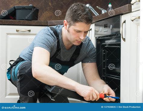 Handyman repairing a kitchen oven