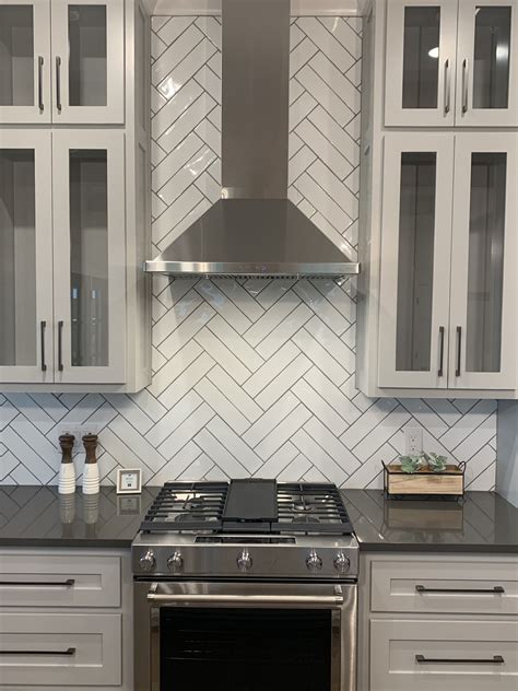 3x6 white subway tile in a herringbone pattern with light gray grout FINISHES Floors, Walls