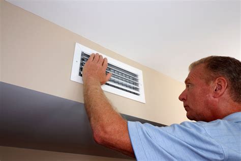 Homeowner checking their heating system vent