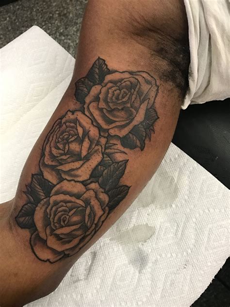 Graphic style red rose tattoo on the inner forearm.