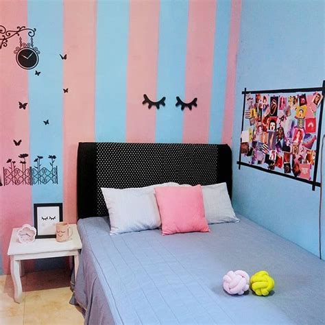 Kamar berdinding biru dongker dengan aksen dekorasi pink