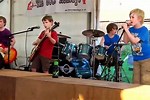 Kid Performing On Stage with Bands
