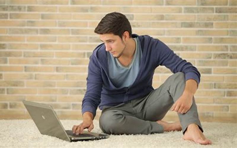 Man Using Laptop While Sitting On The Floor