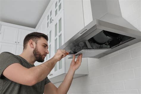 Man Repairing Kitchen Vent Hood