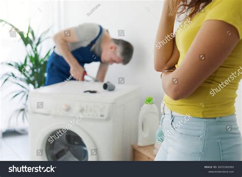 Man looking at a broken washing machine