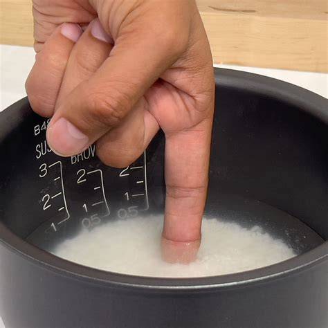 A woman measuring rice in a measuring cup