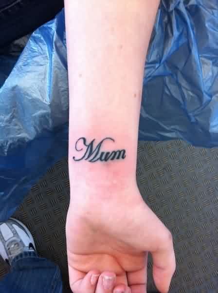 Wrist tattoo saying “Mom” together with a feather on