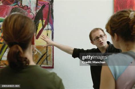Museum guide pointing to art