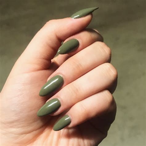 Cute almond shaped dark green nails with two accent white nails with