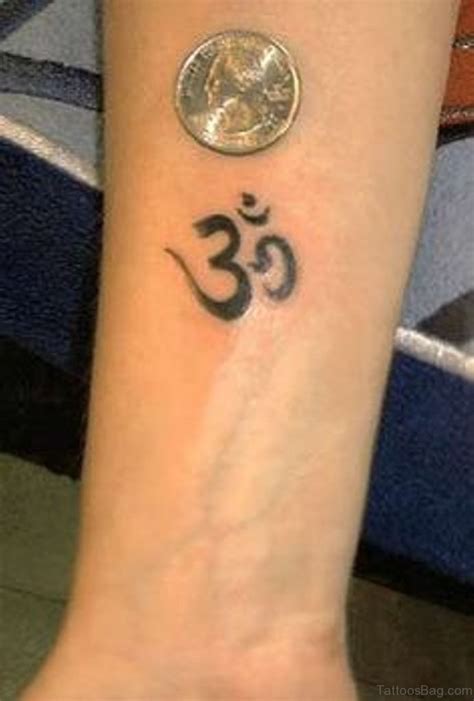 Small, black Om symbol tattoo on the right forearm Om