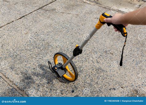 Person Using a Measuring Wheel to Measure Distance