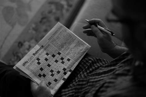 Person focused on solving a crossword puzzle