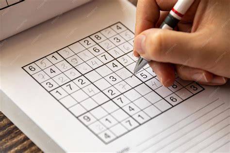 Person solving sudoku puzzle.