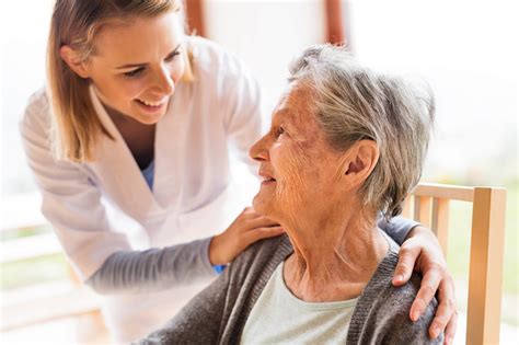 A photo of a caregiver providing personalized care to a senior in a memory care facility
