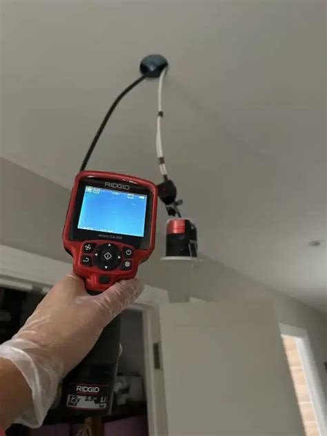 Plumber using leak detection equipment
