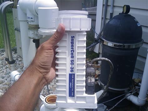 Pool repair technician checking salt cell