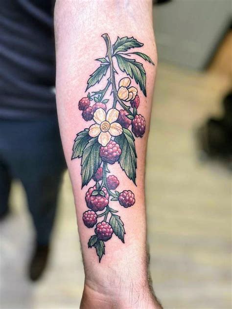 Black and grey raspberry branch tattoo on the right bicep