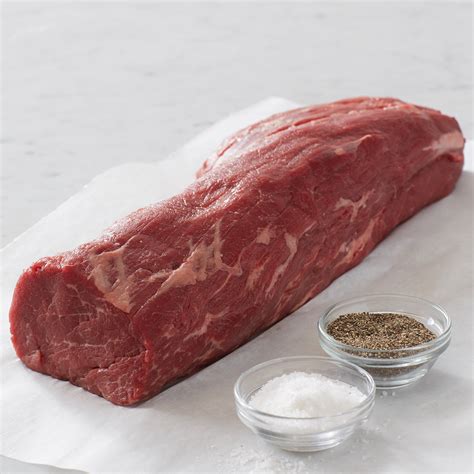 Raw beef tenderloin slices seasoned with salt and pepper