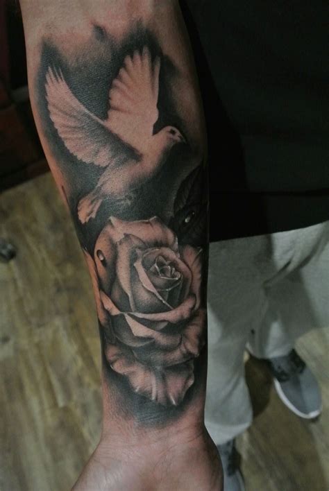 flying dove with roses and ribbon tattoo on sleeve