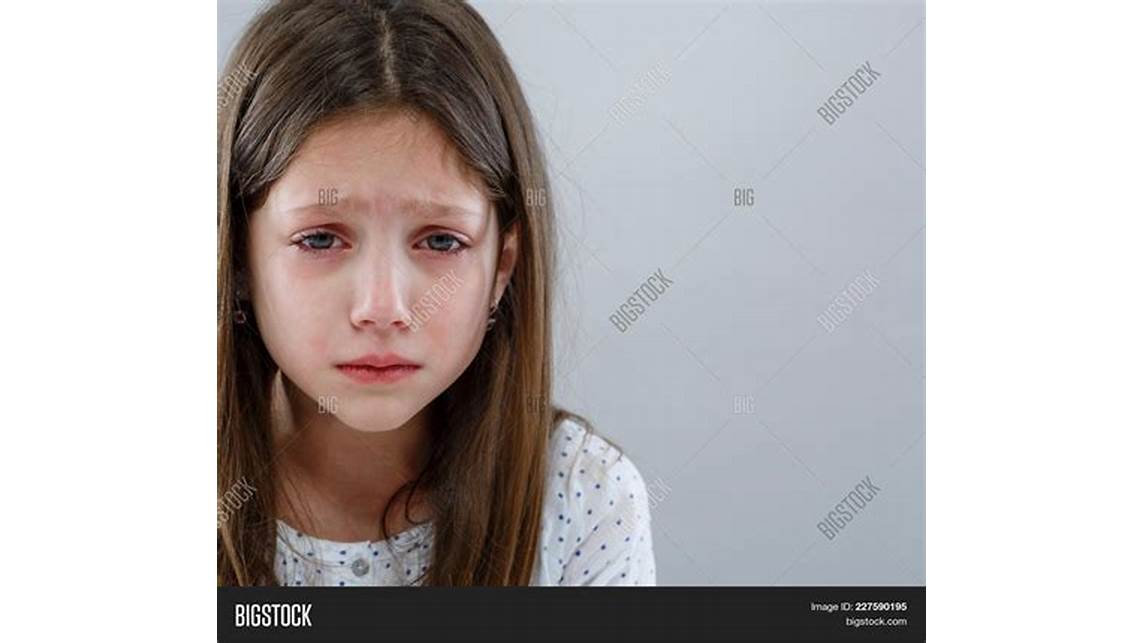 Sad girl looking at old photo